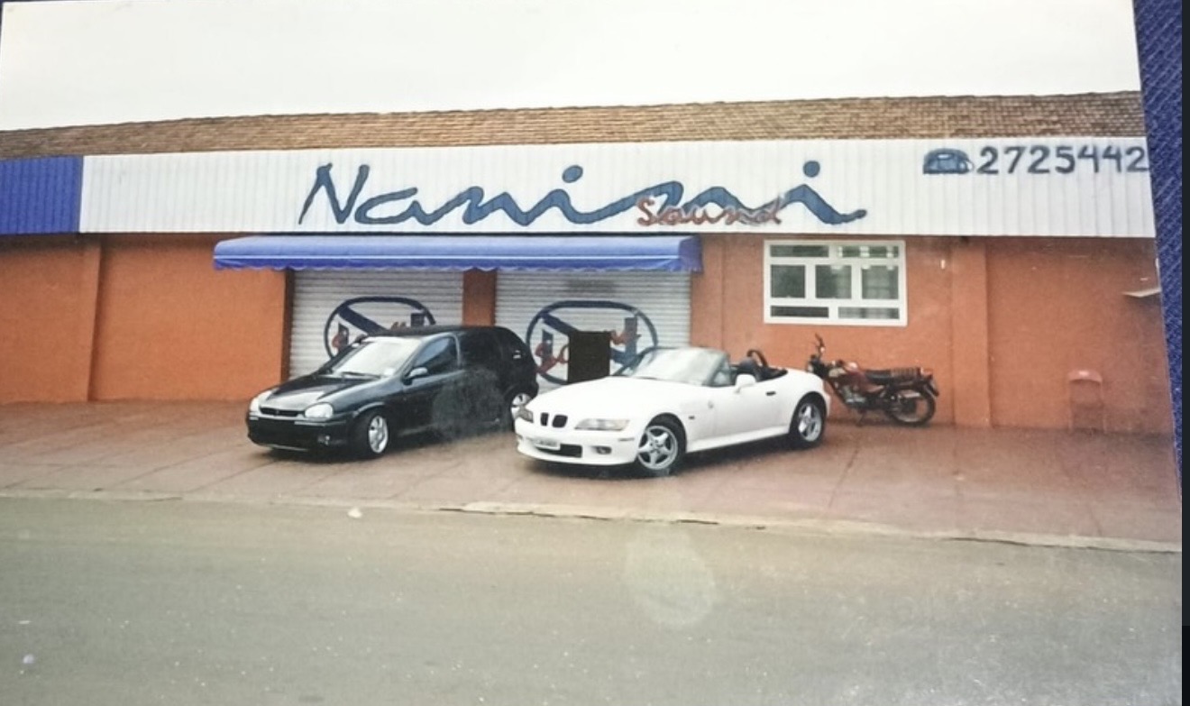 Fachada histórica da Nanini Som com carros estacionados em frente